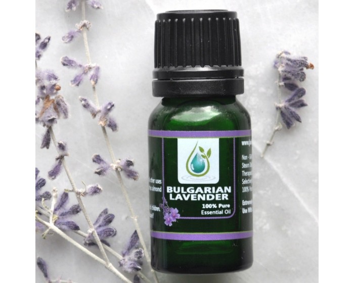 A bulgarian essential oil bottle surrounded by lavender flower stems and flowers.