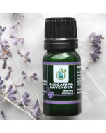 A bulgarian essential oil bottle surrounded by lavender flower stems and flowers.